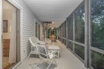 Main level screen porch has multiple seating areas to relax or enjoy a meal